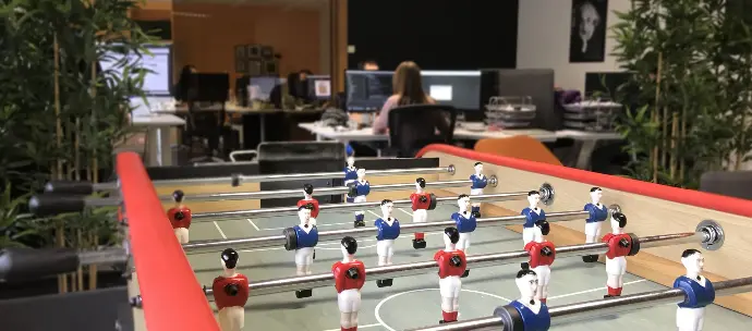 Vue de bureau de AlloTools avec babyfoot et développeurs en background