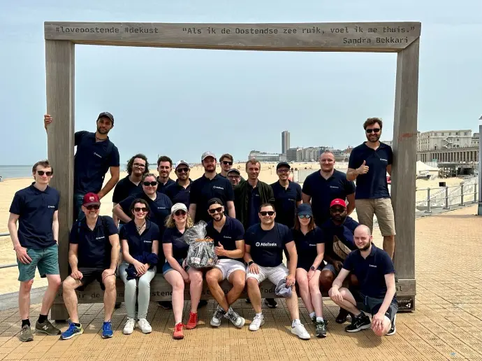 Équipe AlloTools lors du teambuilding 2023 à la mer en Belgique, posant devant un cadre sur la plage d’Ostende