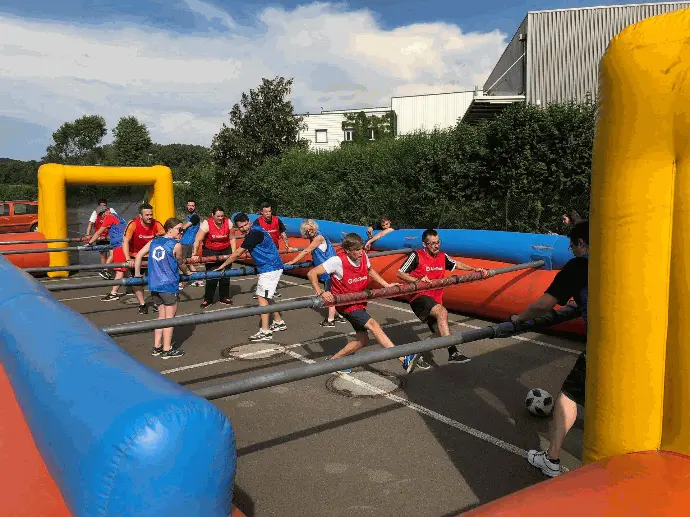 Partie de babyfoot humain lors d’un teambuilding AlloTools, les équipes s’affrontent en extérieur par beau temps